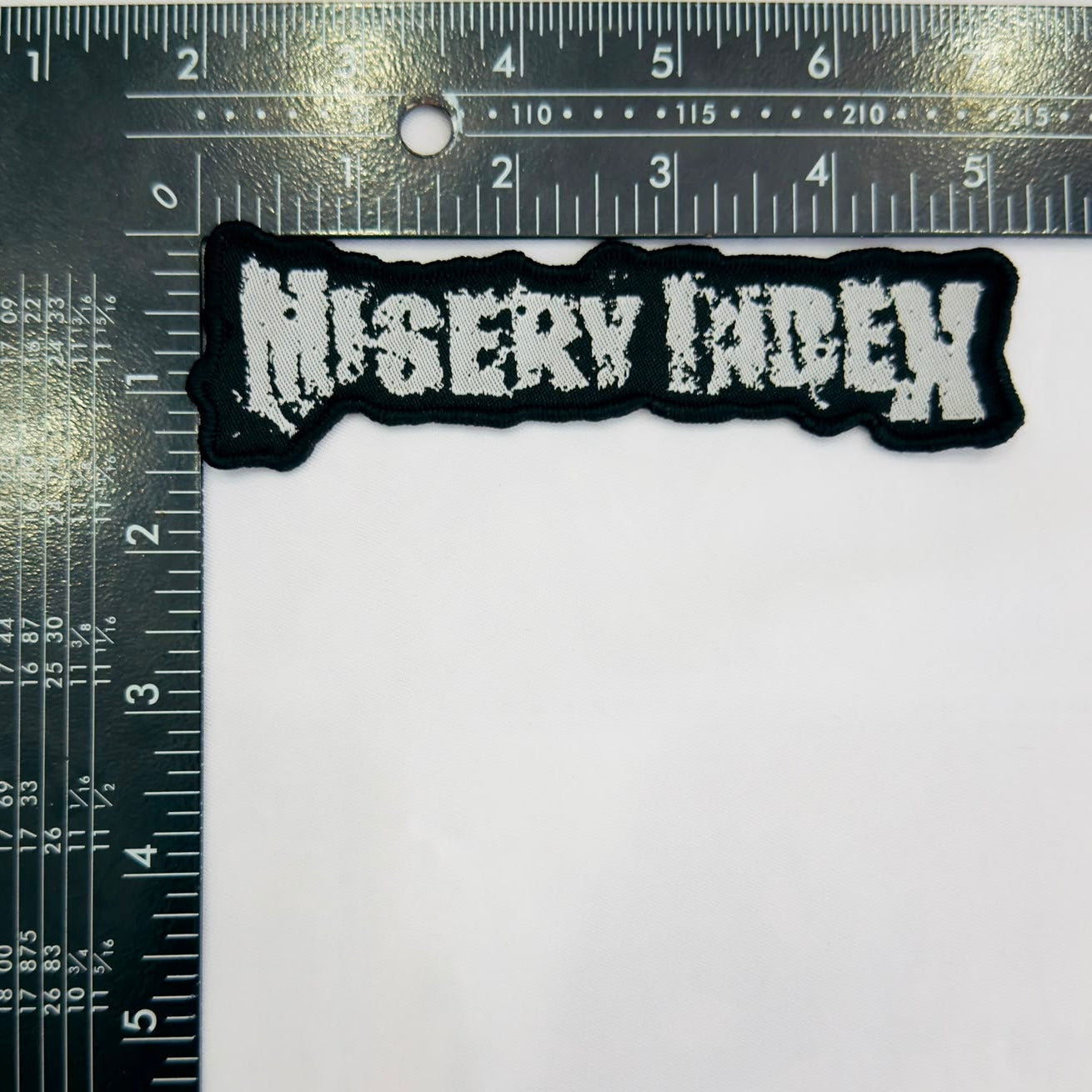 misery-index-logo-cusson-tiss-bordure-blanche image 3