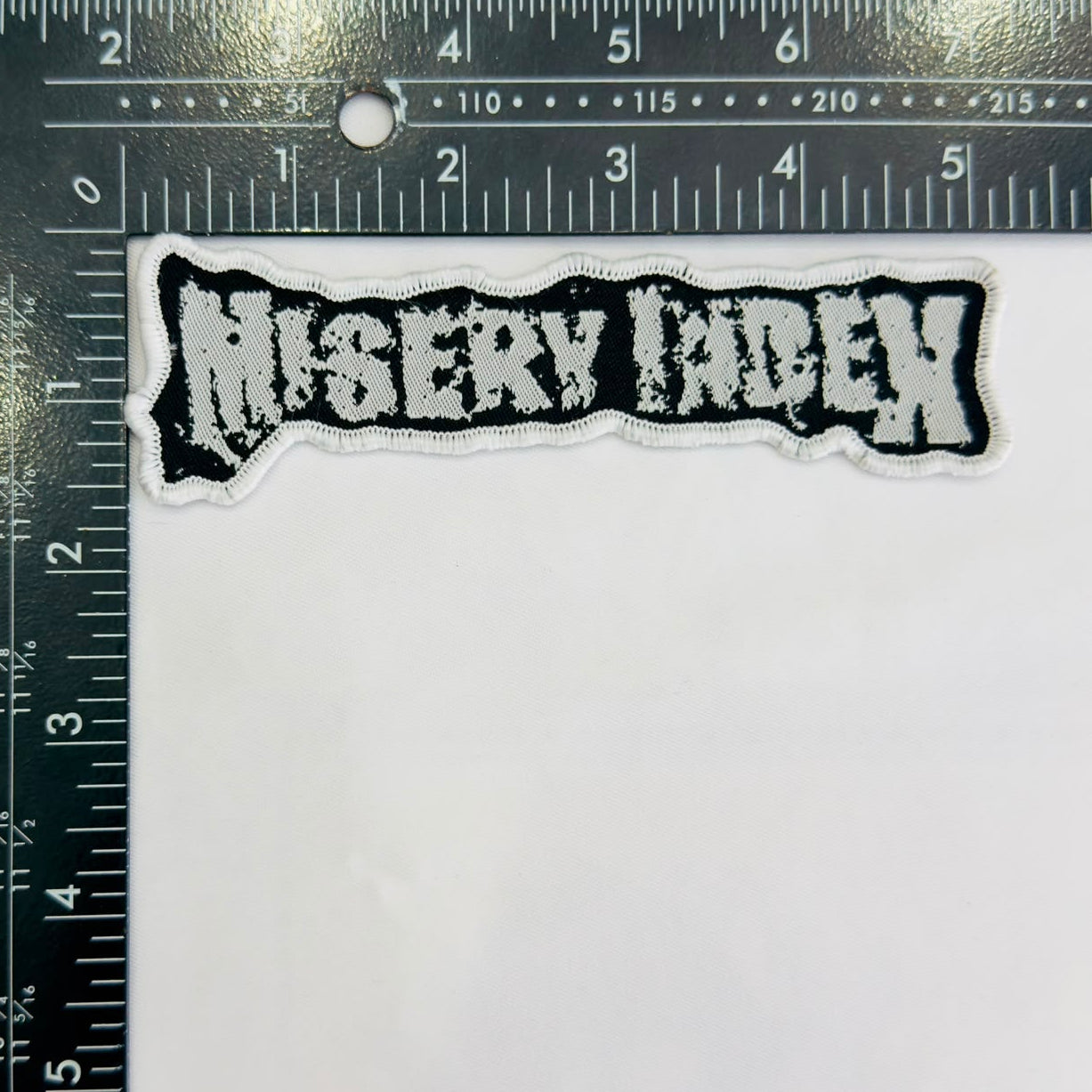 misery-index-logo-cusson-tiss-bordure-blanche image 5