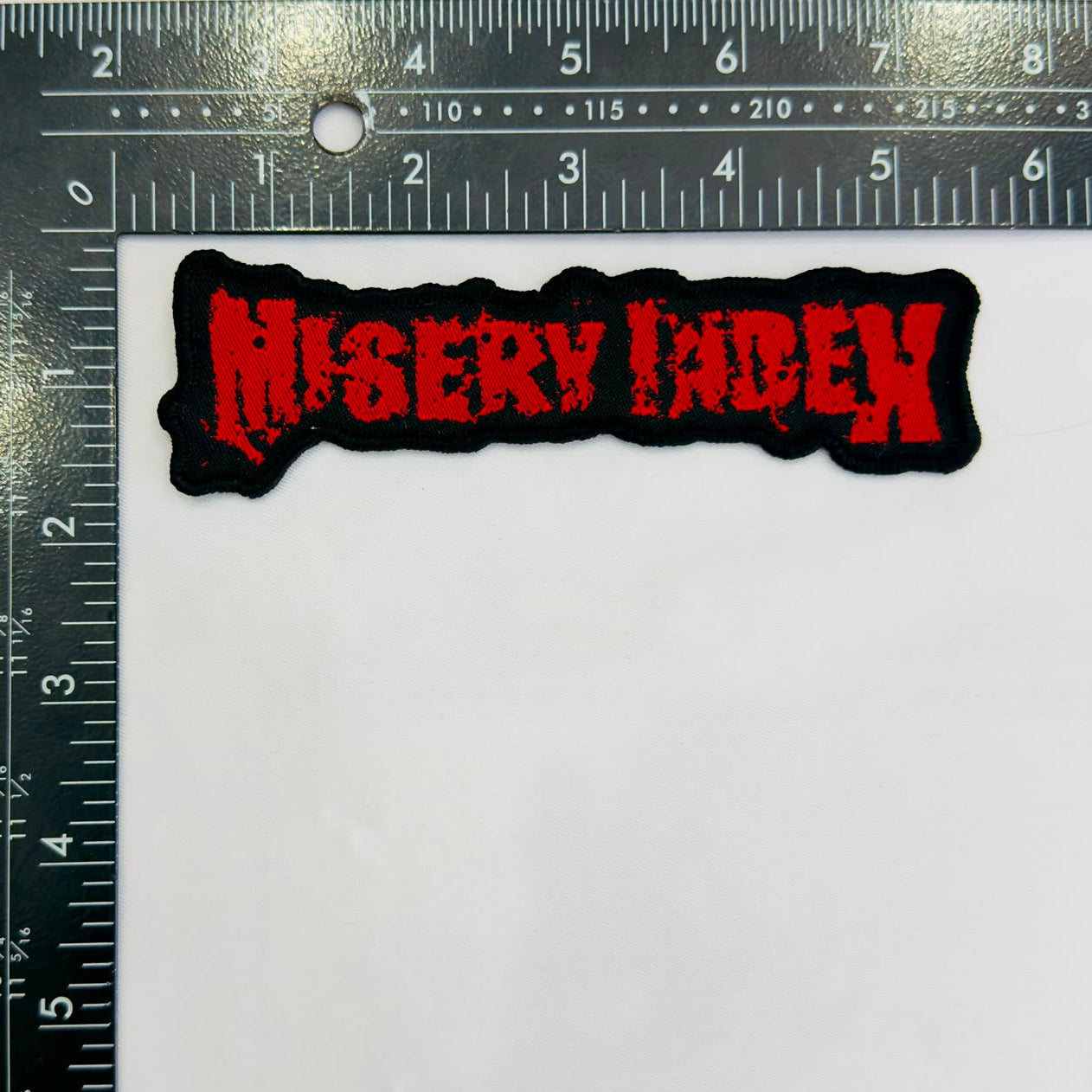 misery-index-logo-cusson-tiss-bordure-blanche image 7